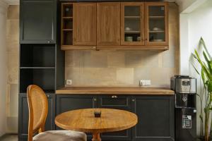 a kitchen with wooden cabinets and a wooden table at Goya Courtyard Ubud in Ubud