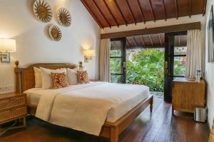 a bedroom with a large bed and a large window at Goya Courtyard Ubud in Ubud +63 photos