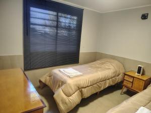 a bedroom with two beds and a large window at Cabaña con parque en Tupungato in Tupungato