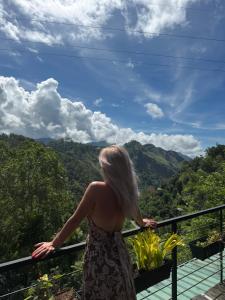 a woman standing on a balcony looking at the mountains at Bethel Ella in Ella