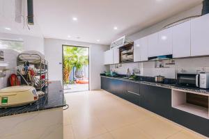 a kitchen with white cabinets and a counter top at LakeView Villa BT43-03 Sầm Sơn in Sầm Sơn