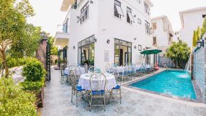 a patio with a table and chairs next to a pool at LakeView Villa BT43-03 Sầm Sơn in Sầm Sơn