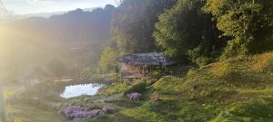 a house on a hill next to a lake at A-Frame House บ้านเอเฟรม แดลอร์ปู in Ban Yang