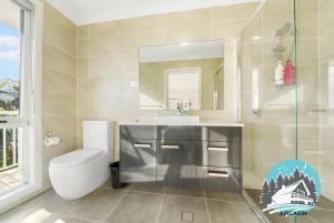 a bathroom with a sink and a toilet and a mirror at 1B house beachside comfy stay in Collaroy