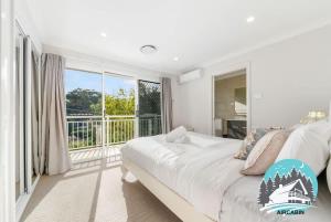 a bedroom with a bed and a large window at 1B house beachside comfy stay in Collaroy