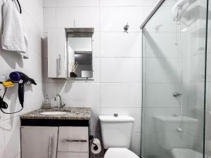 a bathroom with a shower and a toilet and a sink at Apê completo p/ 3 • vaga + Wi-Fi in Brusque