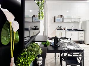 a dining room with a table and chairs and a kitchen at Apê completo p/ 3 • vaga + Wi-Fi in Brusque
