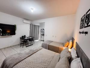 a hotel room with two beds and a table at Apê completo p/ 3 • vaga + Wi-Fi in Brusque