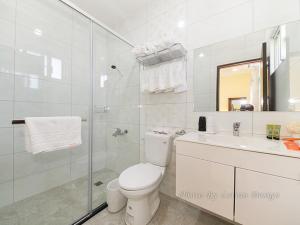 een witte badkamer met een toilet en een douche bij 微笑18民宿 附車位 in Wujie