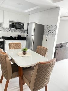 a kitchen with a white table and chairs at Morada dos Pássaros - Casa - 3 quartos e garagem in Vitória da Conquista