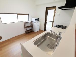 a white kitchen with a sink and a stove at Knowledge House in Odawara +35 photos