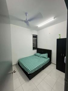 a bedroom with a bed in a white room at Nady's Homestay in Banting