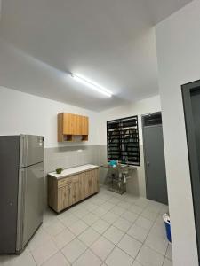 a kitchen with a refrigerator and a table in it at Nady's Homestay in Banting