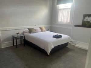 a bedroom with a bed with a table and a window at The Victoria Hotel in Collie