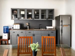 a kitchen with a glass table and a stainless steel refrigerator at Villas Flora Bella Sunflower in Dauis