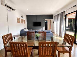 a dining room with a table and chairs and a couch at Villas Flora Bella Sunflower in Dauis