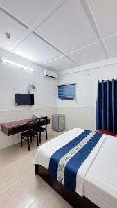 a bedroom with a bed and a desk in it at VICTORY - hotel 388 htp in Ho Chi Minh City