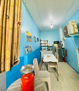 a room with a table and chairs and a blue wall at Hidden Grove GuestHouse in General Luna +17 photos