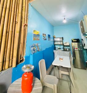 a blue room with a table and a table and chairs at Hidden Grove GuestHouse in General Luna