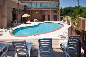 a pool at a hotel with chairs and tables at Holiday Inn Birmingham-Airport by IHG in Birmingham