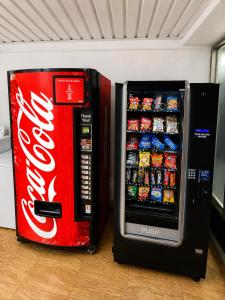 a cocacola soda machine next to a coke refrigerator at The Parker Lodge Fort Smith in Fort Smith