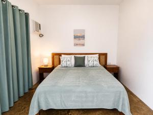a bedroom with a large bed with green curtains at Villas Flora Bella Sunflower in Dauis +18 photos