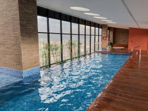 a large swimming pool in a building with a large window at Loft Design Centro Internacional Bogotá in Bogotá