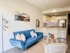 a living room with a blue couch and a kitchen at Loft Design Centro Internacional Bogotá in Bogotá