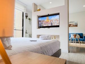 a bedroom with a bed and a tv on the wall at Loft Design Centro Internacional Bogotá in Bogotá +43 photos