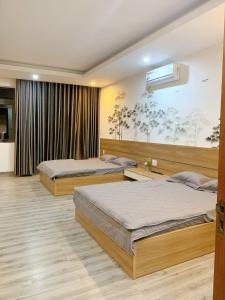 a bedroom with two beds and a tv at Hotel Tâm Đan in Ðông Tác (1)