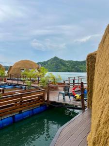 a dock with a table and chairs on a body of water at Coconest THREE Langkawi in Tanjung Rhu