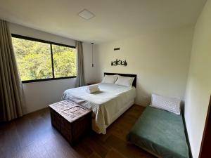 a small bedroom with a bed and a window at Serra Nevada House in Nova Friburgo