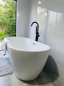 a white bath tub with a faucet in a bathroom at The KWASU Apartments in Chipata +138 photos