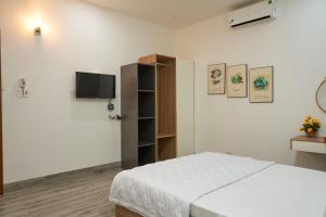 a bedroom with a bed and a tv on the wall at Hotel Tâm Đan in Ðông Tác (1)
