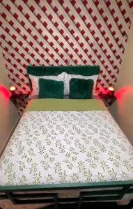 ein Schlafzimmer mit einem Bett mit grün-weißer Bettwäsche in der Unterkunft Rinconcito verde in Constanza