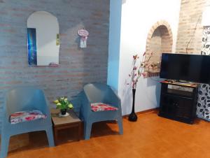a living room with two blue chairs and a television at PUNTO FIJO in Zárate