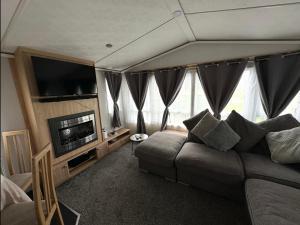 a living room with a couch and a flat screen tv at C43 The Hideout in Rowen