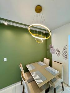 a dining room with a table and a chandelier at Apartamento 2 Quartos Aconchegante - Ar Condicionado nos Quartos - 1 Cama Casal - 2 Camas de Solteiro com Auxiliar - Cozinha Completa - Estacionamento Gratuito in Três Lagoas