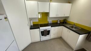 a small kitchen with white cabinets and a sink at Crow's Nest in Picton