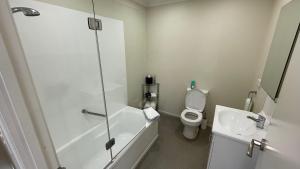 a bathroom with a shower and a toilet and a sink at Crow's Nest in Picton +11 photos