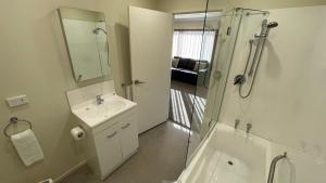 a bathroom with a sink and a shower with a glass door at Crow's Nest in Picton