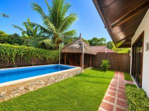 an image of a backyard with a swimming pool and an umbrella at Villas Flora Bella Sunflower in Dauis