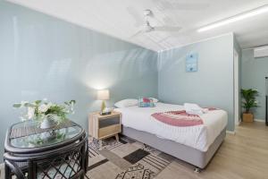 a bedroom with a bed and a glass table at Ocean Parade Motel in Coffs Harbour +76 photos