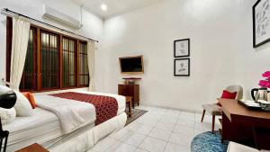 a hotel room with a bed and a desk and a desk at Suite Room The Megatruh in Kejayan