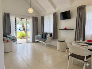 ein Wohnzimmer mit Tisch und Stühlen in der Unterkunft Muri Beachcomber in Rarotonga