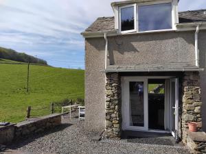 a stone house with a window and a door at Tudor Cottage, Newby Bridge in Ulverston