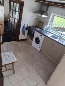 a kitchen with a washing machine and a sink at Tudor Cottage, Newby Bridge in Ulverston