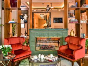 a living room with two chairs and a fireplace at The Artisan Hotel Istanbul - MGallery Collection in Istanbul