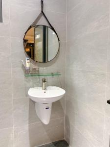 a bathroom with a sink and a mirror at Hotel Tâm Đan in Ðông Tác (1)