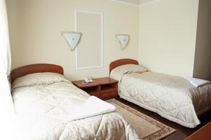1 dormitorio con 2 camas y mesa de madera en Europa Hotel, en Noyabrsk